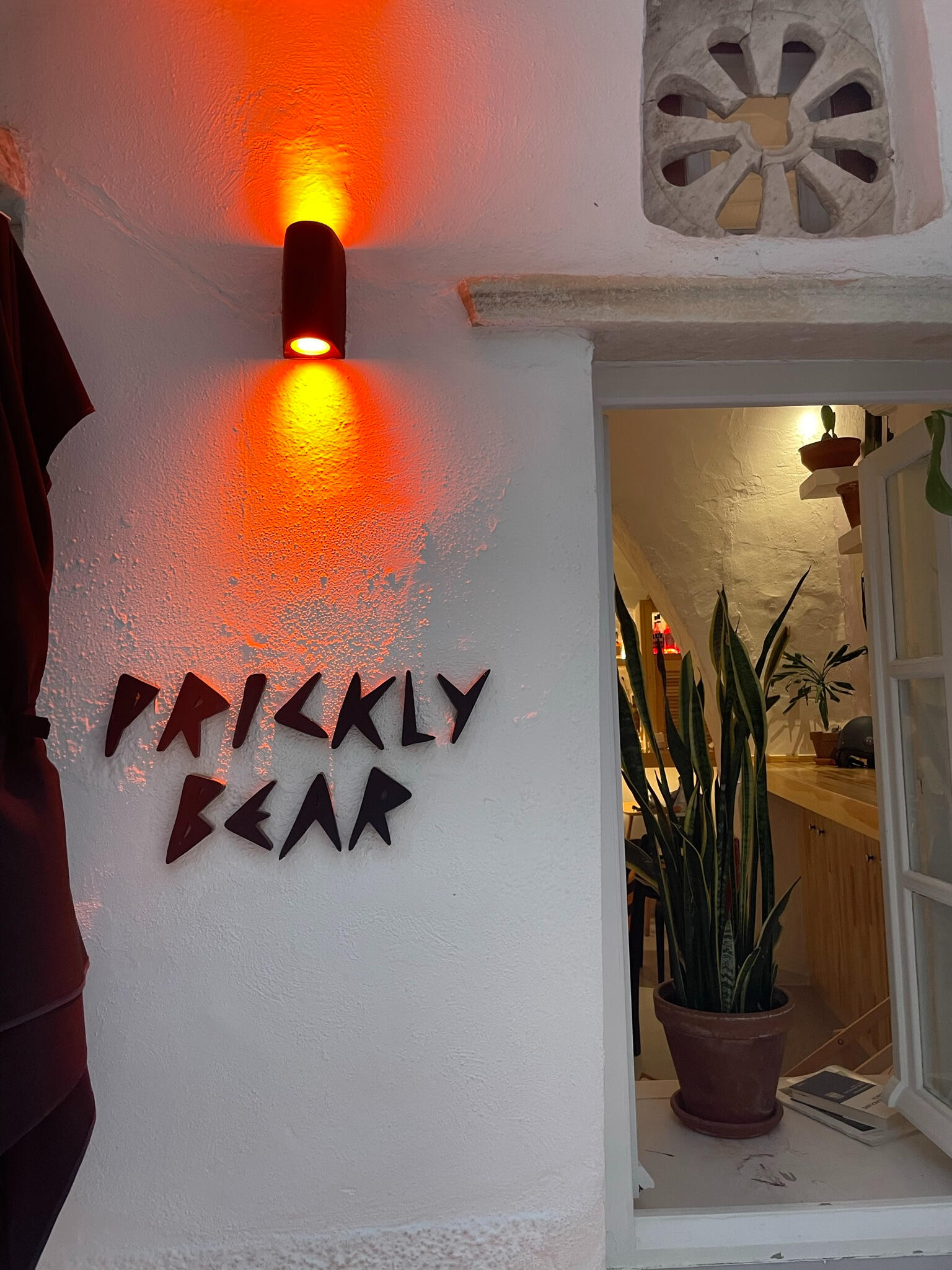 "Entrance to Prickly Bear café in Tinos, Greece, with warm lighting and stylish décor. A cozy spot for specialty coffee, fresh bites, and a relaxed atmosphere."